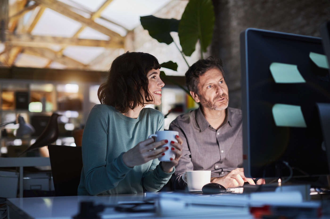 Man and woman sitting in office working on computer