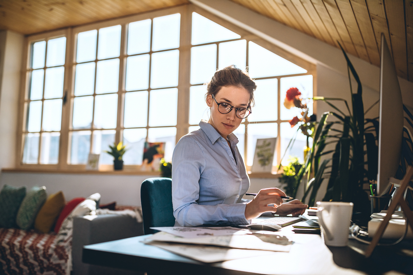 Professional woman working at a desktop computer at an SMB known to be especially vulnerable to cyber attacks