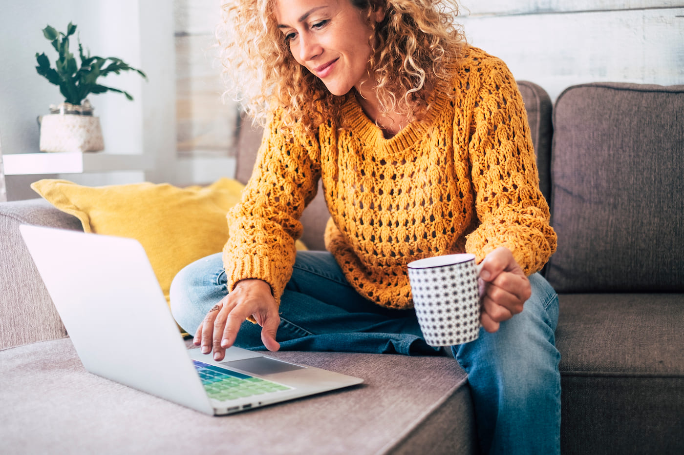 Professional woman casually working from home on a laptop protected against ransomware attacks by zero trust security architecture