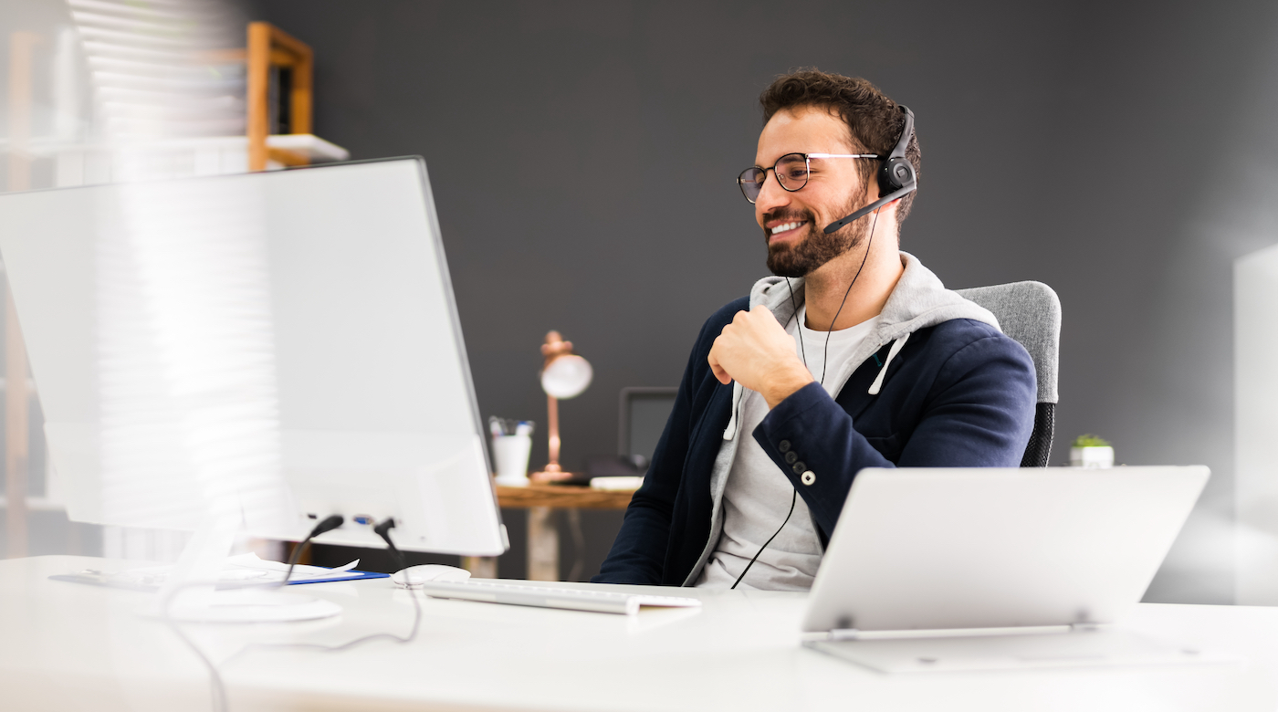 Inidvidual sitting in home office with headset representing the world of contact center technology.