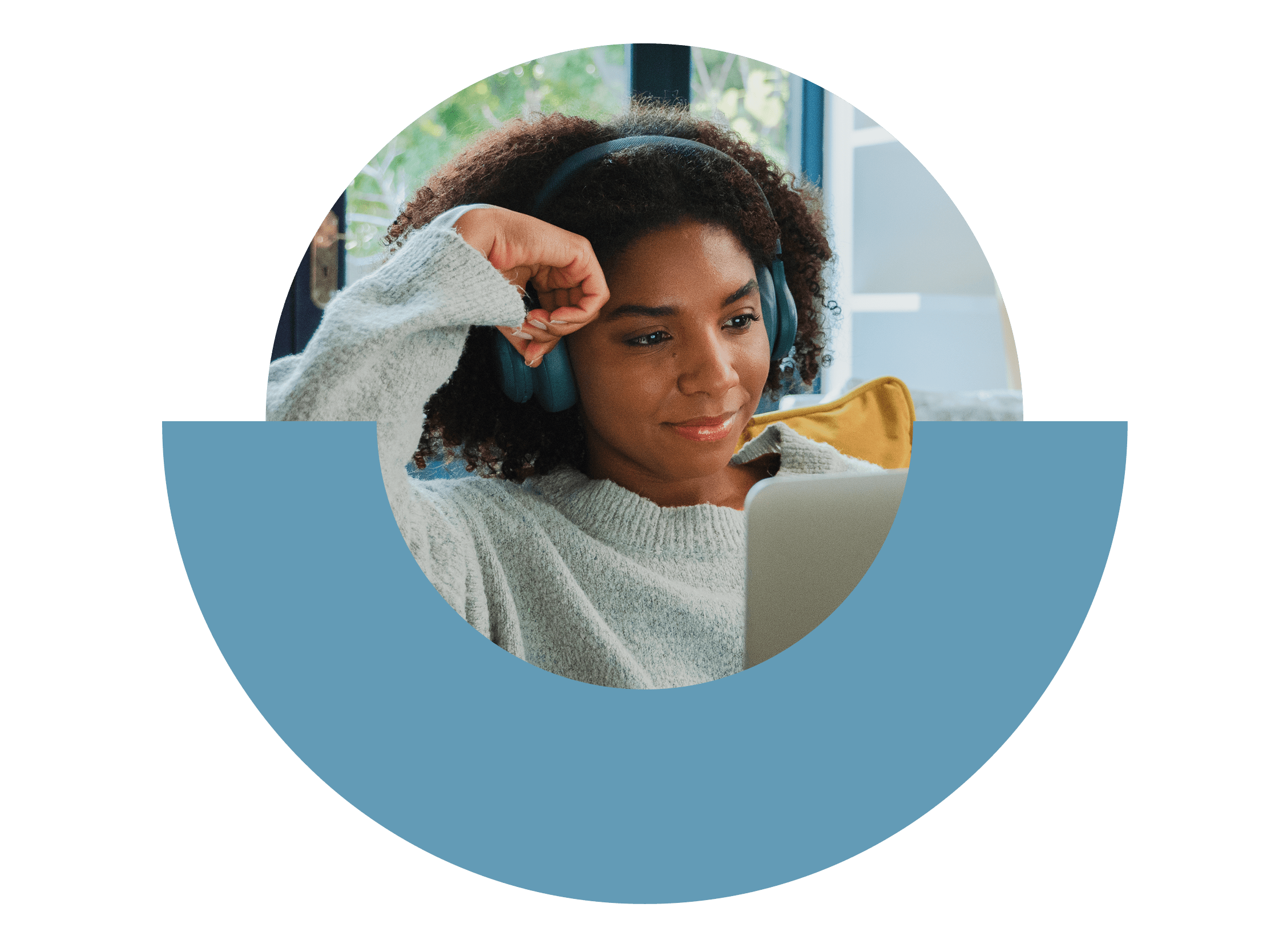 Persona seduta sul divano con le cuffie, che guarda il portatile