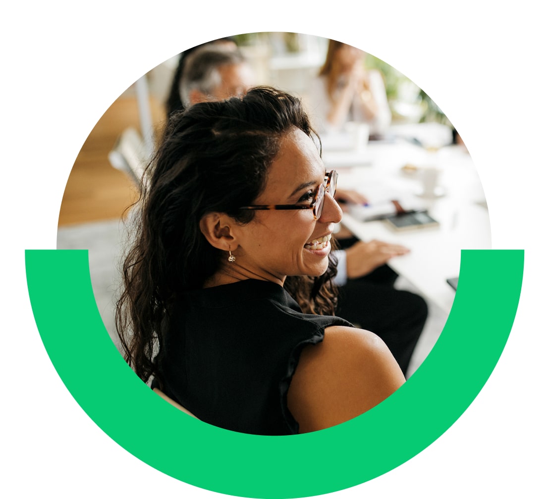 Femme interagissant avec des collègues dans un bureau.