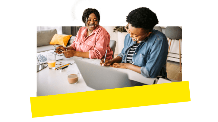 Two coworkers laughing and enjoying themselves while working remote.