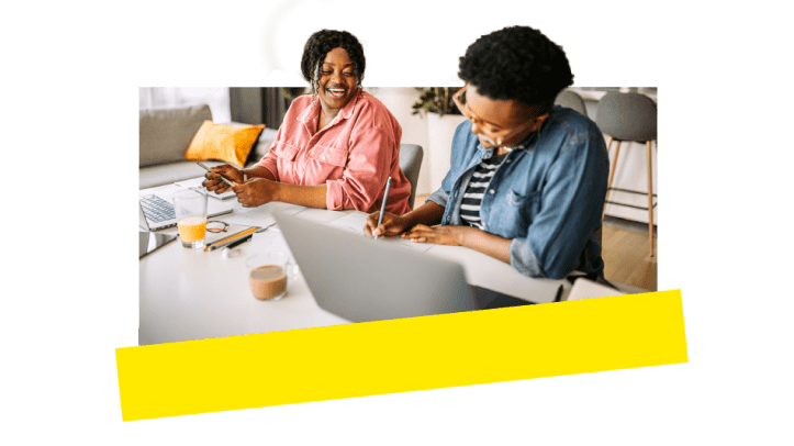 Two coworkers laughing and enjoying themselves working together using VOIP tools.