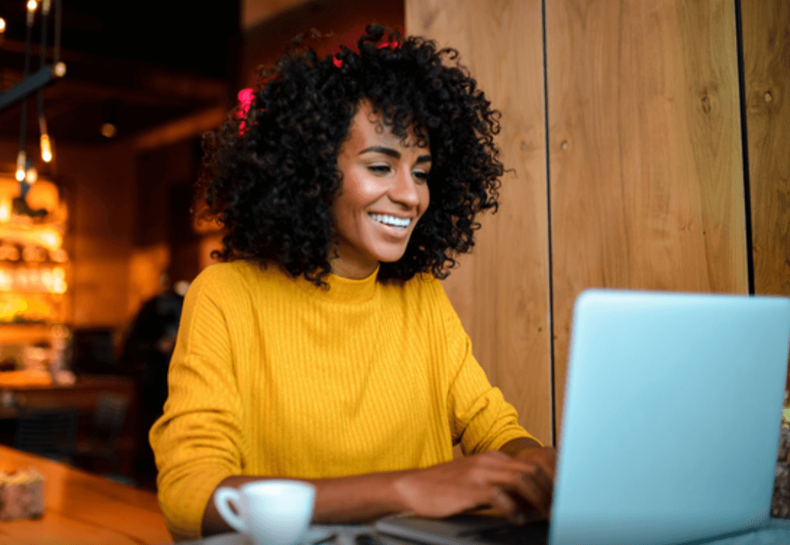 Donna sorridente che lavora con un laptop.