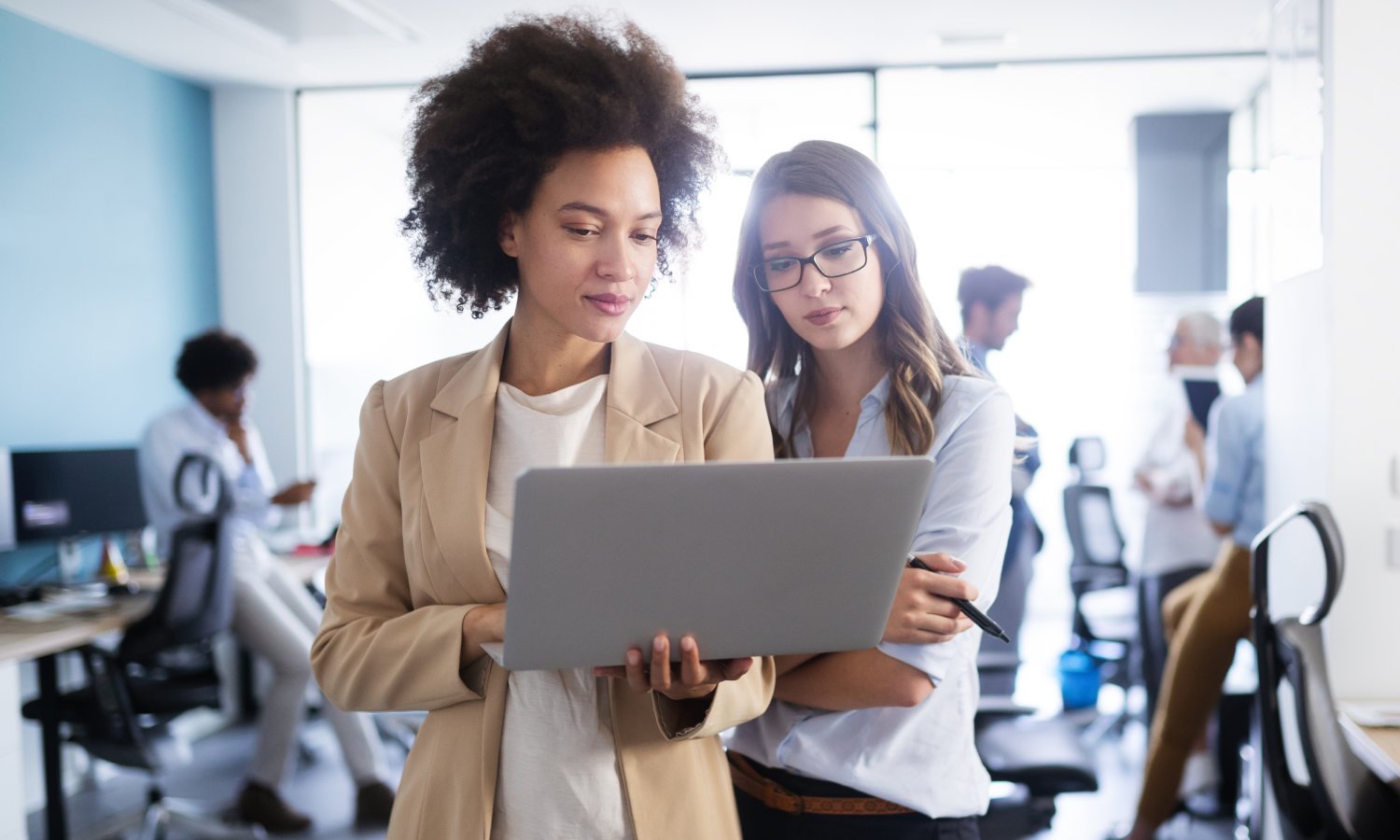 Employees collaborating around a laptop.